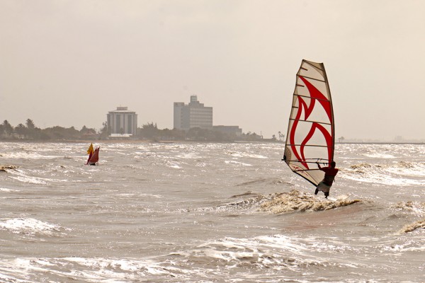 Surfing along the Kitty Seawalls with the Pegasus Hotel and the Marriott Hotel in the backdrop (Arian Browne photo)