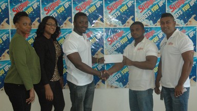  President of the Guyana Bodybuilding and Fitness Federation, Keavon Bess (left) collects the sponsorship cheque from Brand Manager of M. Beepat and Sons, Treion D’Anjou in the presence of members of the federation. 