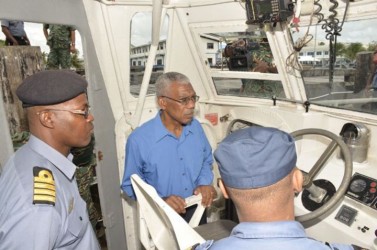 President David Granger (centre) being briefed on some of the daily operations of the Coast Guard while on board one of the Unit’s patrol vessels (GINA photo) 