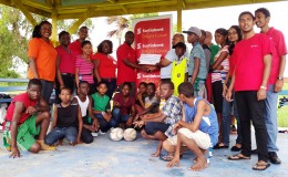 Some of the youth rugby players along with Scotiabank’s Robb Street staffers pose with the cheque at the National Park yesterday.
