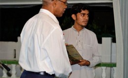 Fazil Azeez’s son (right) receiving the award from President David Granger (ACIC photo)