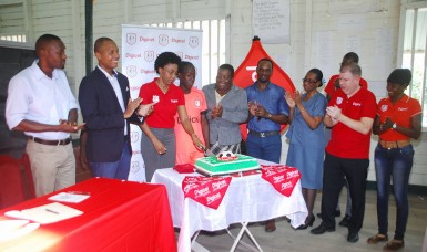 Digicel Head of Marketing Jacqueline James (third from left) alongside members of the launch party cutting the cake to signify the start of their football season yesterday at the Beterverwagting (BV) Secondary School auditorium.