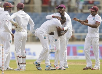 The players celebrate with Jerome Taylor on day one of the second Test West Indies v Australia at Sabina Park, Kingston, Jamaica yesterday. Photo by WICB Media/Randy Brooks of Brooks Latouche Photography