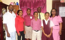 All Saints Primary School’s top three NGSA 2015 performers flanked by parents and teachers. The students are (from left) Travis Isaacs Jr, Jahiem Hutson and Cassandra Kippins.