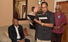 Prime Minister Moses Nagamootoo taking the oath in the presence of Chancellor of the Judiciary (ag) Justice Carl Singh. Also in photo is Chief Protocol Officer Vic Persaud (GINA photo)
