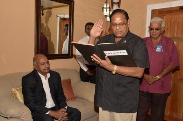 Prime Minister Moses Nagamootoo taking the oath in the presence of Chancellor of the Judiciary (ag) Justice Carl Singh. Also in photo is Chief Protocol Officer Vic Persaud (GINA photo)