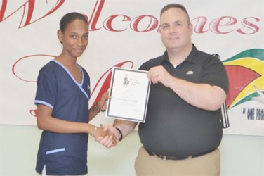 Dan Batsie (right), head of the Atlantic Emergency Medical Service presenting a certificate to one of the participants (GINA photo)