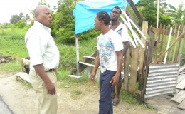 Community Coordinator Neilson McKenzie interacting with residents of B Field, Sophia. (Ministry of Public Infrastructure photo)