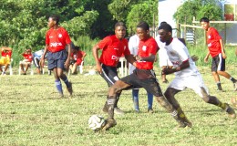 Action between Friendship Secondary (red) and Xenon Secondary (white) during the Digicel Secondary Schools Football Championship at the Grove Community ground. 