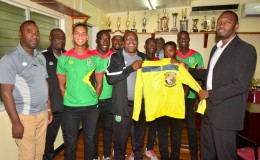 Head Coach Jamaal Shabazz presents Director of Sports Christopher Jones with memorabilia during the National U-23 team’s courtesy call yesterday
