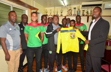 Head Coach Jamaal Shabazz presents Director of Sports Christopher Jones with memorabilia during the National U-23 team’s courtesy call yesterday  