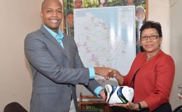 GFF Normalization Committee Chairman Clinton Urling (left) hands over a ball to Minister within the Ministry of Indigenous Affairs Valerie Lowe-Garrido during a brief handing over ceremony. (Orlando Charles photo)