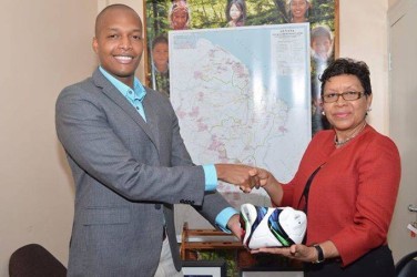 GFF Normalization Committee Chairman Clinton Urling (left) hands over a ball to Minister within the Ministry of Indigenous Affairs Valerie Lowe-Garrido during a brief handing over ceremony. (Orlando Charles photo)