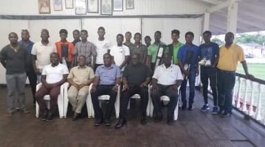 The DCC National youth players pose with their gears while executives of the DCC and Clive Lloyd are seated in front. 