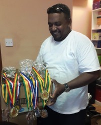 Payless Variety Store’s Rajan Tiwari displays some of the trophies and medals that will be up for grabs tomorrow.  