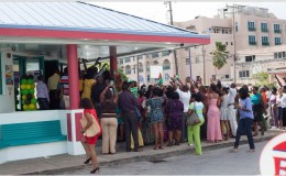Guyanese gathered outside Bubba’s Sports Bar in Hastings, Christ Church, Barbados try to get a glimpse and take a photo of the president.