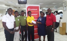 National U15 player Alphius Bookie accepts the sponsorship cheque from Scotiabank Manager Brian Hackett in the presences of his fellow teammates, DCC President Alfred Mentore and Karen Harris, Scotiabank’s Relationship Officer.