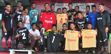 Captain of the victorious Port Kaituma Secondary Raymond Daniels receiving the championship trophy from District Education Officer Ignatius Adams (8th from right) and Digicel Representative Althea Pollard (6th from right) while other members of the team display their new team kits following their win over Santa Rosa in the zone finale.  