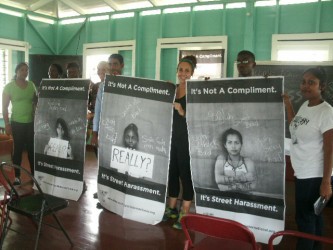Witness Project representatives and Peace Corps Volunteers holding up the campaign posters at the New Amsterdam Prison Officers’ Club