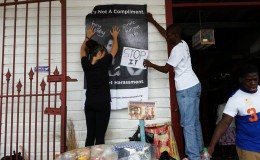 Witness Project volunteers erecting a poster in front of the New Amsterdam Municipal Market
