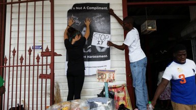 Witness Project volunteers erecting a poster in front of the New Amsterdam Municipal Market 
