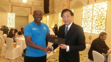 Steve Ninvalle receiving his AIBA tie from president of the body Dr. Ching-Kuo Wu on Wednesday during the four-day congress in Doha, Qatar. 