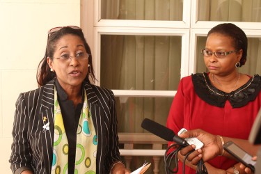Suzanna Nichols addressing reporters as Social Protection Minister Volda Lawrence looks on. 