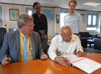 Ambassador Robert Kopecký (seated at left) and Anand Goolsarran signing the contract while EU Programme Officer  LaToya DeMendonca-Blair and EU Head of Cooperation Ewout Sandker look on. (EU photo)  