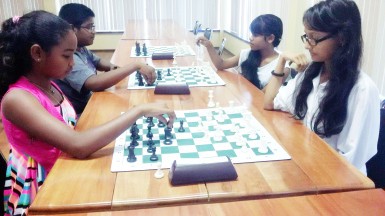 Felicity Sonaram, 13 (left) a student at St Stanislaus College, opposes Sheriffa Ali, 16, of St Joseph High, during the lunch interval of last Sunday’s rapid chess tournament at the National Resource Centre in Woolford Avenue. Both students have been identified to represent Guyana at the Guyana Games which are to be held here next month. In the background, Joshua Gopaul, 15, of Saints, takes on his sister Ellen, a student at Zeeburg Secondary. Joshua captured the top junior chess prize in Sunday’s competition and has also been earmarked to represent his country at the Guyana Games. 
