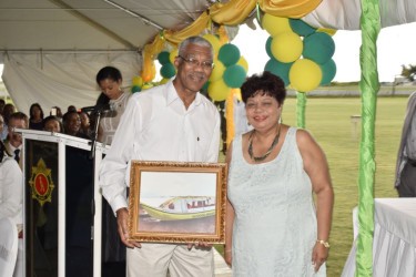 Social Cohesion Minister Amna Ally presents President David Granger with a framed photo of the boat. (Ministry of the Presidency photo) 