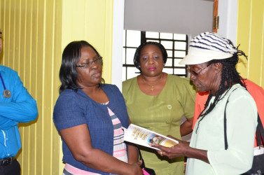Minister within the Ministry of Public Health, Dr Karen Cummings (left) in discussion with a resident of Buxton during a visit to the village’s health centre (GINA photo)