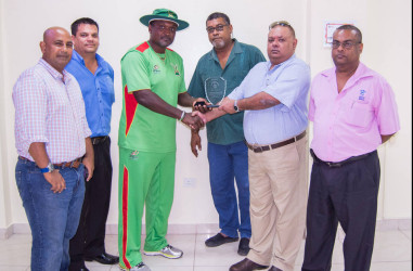 Amazon Warriors coach and former Georgetown Cricket Club player Carl Hooper receives his award from GCC president Lionel Jaikaran at a simple ceremony last evening at the Providence National Stadium. 