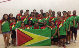 OVERALL CHAMPS! Guyana’s junior boys and girls’ teams along with officials Garfield Wiltshire and Carl Ince bask in the moment.
