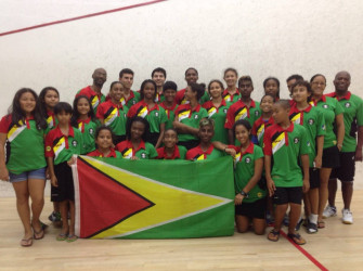 OVERALL CHAMPS! Guyana’s junior boys and girls’ teams along with officials Garfield Wiltshire and Carl Ince bask in the moment. 
