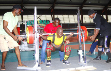 Winston Stoby squatting yesterday at the Claude Charles Memorial Intermediate and Masters Championships at the National Gymnasium. (Orlando Charles photo)