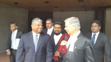 Anand Ramlogan (left) leaving the Hall of Justice with his lawyers. 