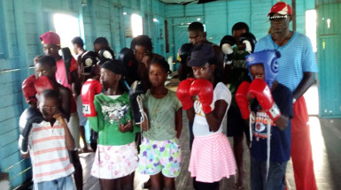 Some of the members of the Ann’s Grove Boxing Gym posit with the new gloves that were presented to them on Thursday by the Guyana Boxing Association.