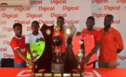 Digicel’s representative Sherwin Osborne (centre) poses with Head Coaches Vurlon Mills (left) and Anthony Stephens (right) along with team captains Amanackie Forde (2nd left) and Tevin Crawford and the Lien trophy yesterday.
