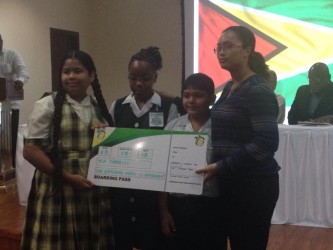 Solomon Cherai (second from right) and Shania Eastman (second from left), of Success Elementary, and Celine Farinha (left), of Peter’s Hall Primary, the top three performers at the NGSA, and a representative from Fly Jamaica.
