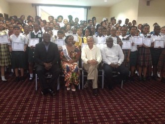 Minister of Education Dr Rupert Roopnaraine (seated second from right), Chief Education Officer Olato Sam (seated at left) and Miss Guyana UK Zena Bland flanked by the successful NGSA students. 