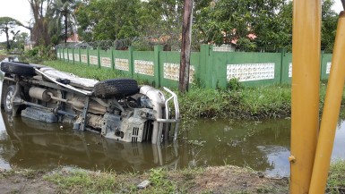 This vehicle ended up on its side in the trench alongside Mandela Avenue just outside President David Granger's home this morning. It was not immediately clear what caused the accident. 