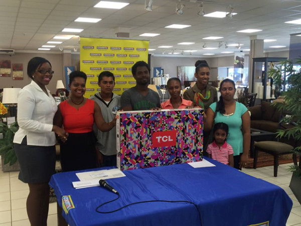 Public Relations Officer Roberta Ferguson (left) presenting to seven of ten customers. Courts awarded 10 customers who bought a TCL television during the Caribbean Premier League (CPL) period with a year of Netflix Subscription. 