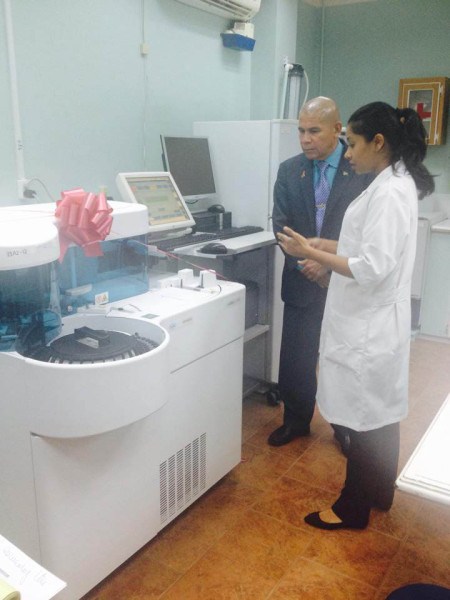 A medical technologist briefing Minister Norton on the Cobas C 311 Chemistry Analyzer  