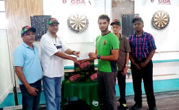 John Maikoo presents the awards to President of the Guyana Darts Association Jamwant Bhupan. Also in the picture are Lallchand Rambharose, Raphael DeSouza and Jamal Holligan.