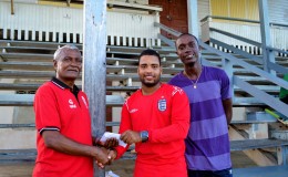 Naushad Mohamed hands over cheque to Rose Hall Town Youth & Sports Club captain Shawn Pereira while Eon Hooper looks on 