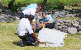 French gendarmes and police inspect a large piece of plane debris which was found on the beach in Saint-Andre, on the French Indian Ocean island of La Reunion, July 29, 2015. Reuters/Zinfos974/Prisca Bigot