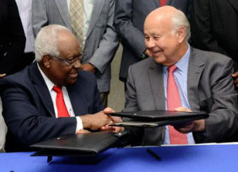 RJR Group chairman, Lester Spaulding (left) and The Gleaner’s Chairman, Oliver Clarke, exchange documents sealing the deal of the merger.