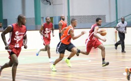 Yannick December  of Pepsi Sonics on the attack while being pursued by Tyrone Hamid of Ravens  during their matchup at the Cliff Anderson Sports Hall