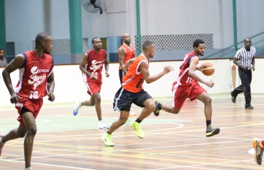 Yannick December  of Pepsi Sonics on the attack while being pursued by Tyrone Hamid of Ravens  during their matchup at the Cliff Anderson Sports Hall