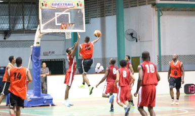 Tyrone Hamid (no.15) of Ravens in the process of attempting a layup while Pepsi Sonics’ Earl O’Neil (centre) tries to block him during GABA League Qualifying Tournament matchup at the Cliff Anderson Sports Hall 